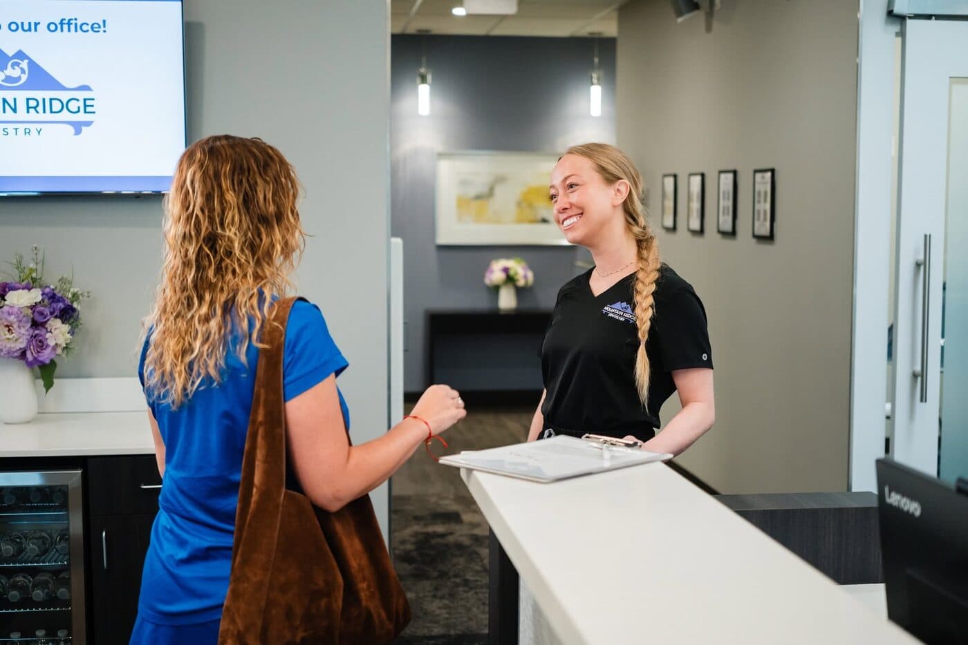 A team member welcoming a patient at the front desk